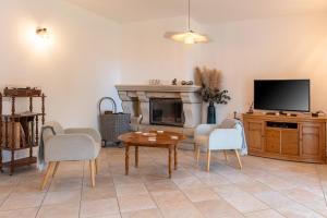 ein Wohnzimmer mit Fernseher und Tisch und Stühlen in der Unterkunft La villa Léa in Saint-Gildas-de-Rhuys