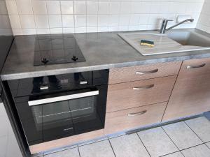a kitchen with a stove and a sink at Appartement centre ville et terrasse in Brive-la-Gaillarde