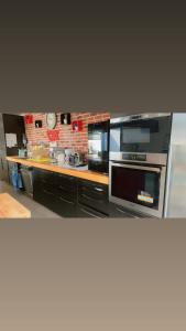 a kitchen with stainless steel appliances and a brick wall at LA VILLa in La Rochelle