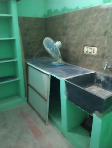 a bathroom with a sink and a fan on a counter at TGB Home Stay in Tiruvannāmalai