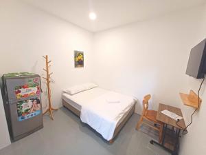 a bedroom with a bed and a small refrigerator at Yen Minh Resthouse in Ho Chi Minh City