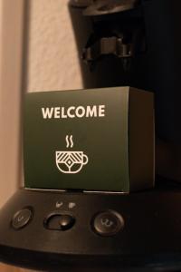 a box with the welcome sign on top of a phone at 50 Nuances Zen - Love Room à Rouen in Rouen