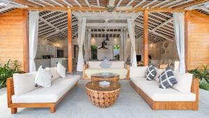 a patio with white couches and a coffee table at Villa Taramille by Villa Finder in Kerobokan