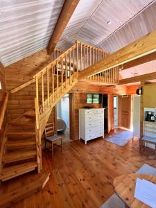 a large room with a wooden staircase in a house at Tallbarren in Rälla +6 photos