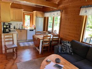 a living room with a couch and a kitchen at Tallbarren in Rälla