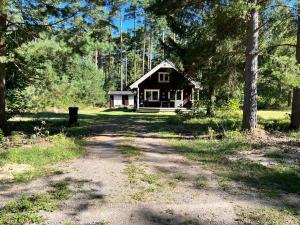 a house in the woods with a dirt road at Tallbarren in Rälla