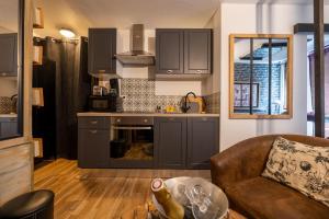 ルーアンにある50 Nuances de Bonheur - Love Room à Rouenの灰色のキャビネットとソファとテーブルのあるキッチン +19枚の写真