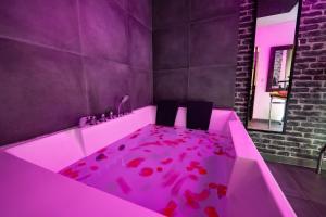 ルーアンにある50 Nuances de Bonheur - Love Room à Rouenのピンクの床のバスルーム(ピンクのバスタブ付)