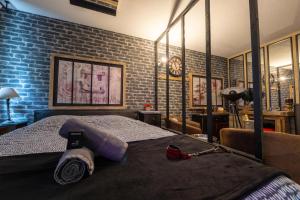 ルーアンにある50 Nuances de Bonheur - Love Room à Rouenのベッドとレンガの壁がある寝室