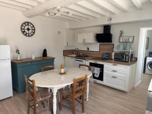a kitchen with a table and chairs in a kitchen at Charmante maison de campagne in La Hoguette