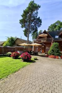 a house with a brick driveway and a tree at Villa Eternity in Jūrmala