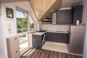 a kitchen with black and white appliances and a window at ASTAREA - Penthouse in nature-free private parking-jacuzzi-terrace & balcony-peace in Zagreb