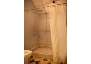 a bathroom with a shower curtain and a toilet at LAKSHDEEP COTTAGES in Canacona