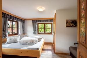 Un dormitorio con una cama y dos ventanas. en Hitscherhof - Abart, en Söll