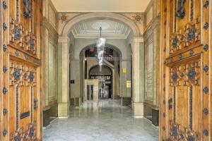 a hallway with wooden doors and a chandelier in a building at The Boulevard by Aspasios in Barcelona
