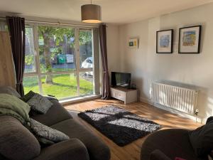 a living room with a couch and a tv at Bright and Central Belfast City Apartment in Belfast