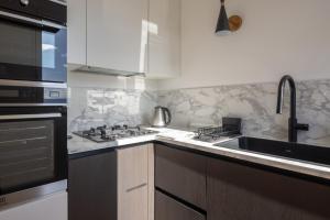 a kitchen with a sink and a stove at Casa Sarina Modern apartment with city and sea view up to 6 ppl garage on request in La Spezia +33 photos