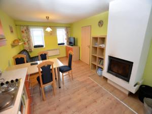 Una sala de estar con una mesa y una chimenea. en Holiday Home Medenec near Alšovka Ski Slope, en Měděnec 32 fotos más