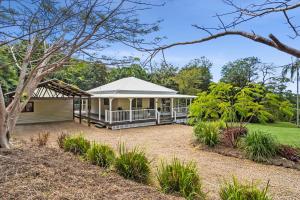 a white house with a porch in a yard at Montville Retreat offgrid luxury in Montville