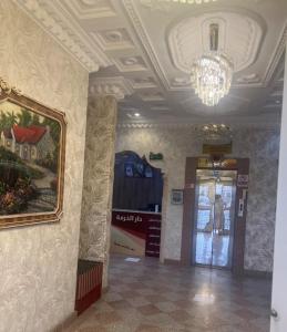 a hallway with a painting and a chandelier in a building at شقق دار الخرمة in Al Khurmah
