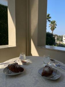 a table with two plates of food and two glasses at Villa Safira in Durrës