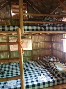 una camera da letto con due letti a castello in una cabina di Socorros nature place ad Antipolo
