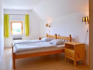 a bedroom with a bed and a window with green curtains at Stupná Holiday Home with Garden in Vidochov