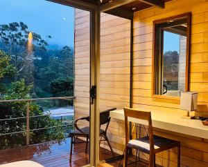 a room with a desk and two chairs and a window at Azenya Nuwara Eliya in Nuwara Eliya