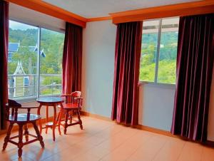 a dining room with a table and chairs and windows at Haweli Restaurant & Guest House in Ao Nang Beach
