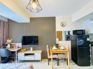 a living room with a black refrigerator and a table at J Tower Residences in Mandaue City