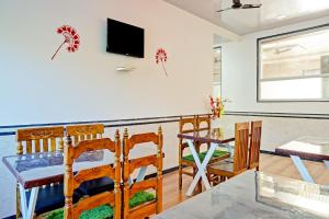 a dining room with a table and chairs and a television at Hotel O Maurya in Pune