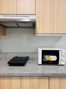 a microwave on a counter in a kitchen at Minimalist Comfort with Homey Touches in Mandurriao +7 photos