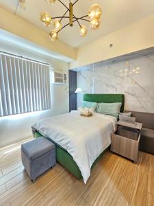 BiñanRM South Staycation的一间卧室，配有一张大床和一扇大窗户。