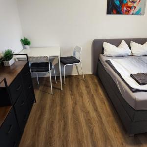 a bedroom with a bed and a desk and a table at Ferienwohnung 2-Zimmer im Herzen von Osnabrück in Osnabrück