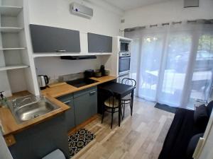 a small kitchen with a sink and a table at Charmant appartement dans une villa in Sospel