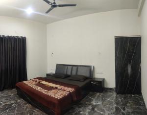 ein Schlafzimmer mit einem Bett und einem Deckenventilator in der Unterkunft Footprints Villa in Panchgani