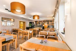 a restaurant with wooden tables and wooden chairs at Hotel Helios in Lipova Lazne