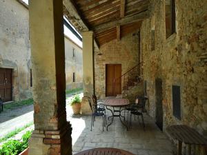a patio with a table and chairs in a building at Tuscan Charm Near Volterra in Volterra