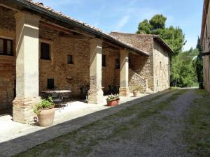 an old stone building with a table in a courtyard at Tuscan Charm Near Volterra in Volterra