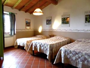 a room with three beds and a chandelier at Tuscan Charm Near Volterra in Volterra