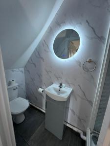 a white bathroom with a sink and a mirror at Golders Park Hotel in London +80 photos
