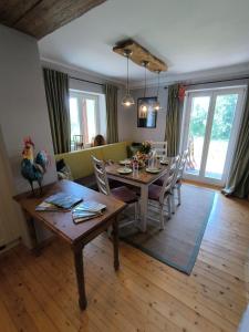 Un comedor con mesa y sillas en Natur und Wellness ''auf der Hardt'' -Jacuzzi- Sauna- Kinderausstattung- Alleinlage im Wald, en Mürlenbach