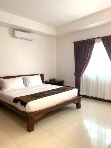 a bedroom with a bed and a window at Hawaii Beach Bungalows in Sihanoukville