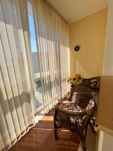 a room with a chair and a large window at Сдам 3х комнатную квартиру у моря! in Chornomorsk
