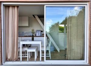 a view of a kitchen and dining room from a window at Tiny House Cosy Climatisée in Saint-Sylvain-dʼAnjou