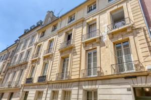 ein Gebäude in Paris mit Fenstern und Balkonen in der Unterkunft Studio Recollet &Cours - Versailles in Versailles