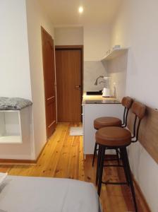 una pequeña cocina con 2 taburetes en una habitación en Cozy and centrally located studio apartment, en Bruselas