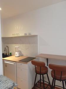 una cocina con 2 taburetes y una barra en Cozy and centrally located studio apartment, en Bruselas