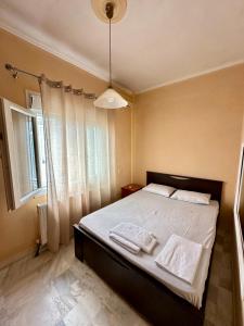 a bedroom with a bed with white sheets and a window at Ikidiki Beach Villa in Ierissos
