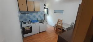 a small kitchen with a stove and a table at Marijana - One bedroom with balcony in Babino Polje